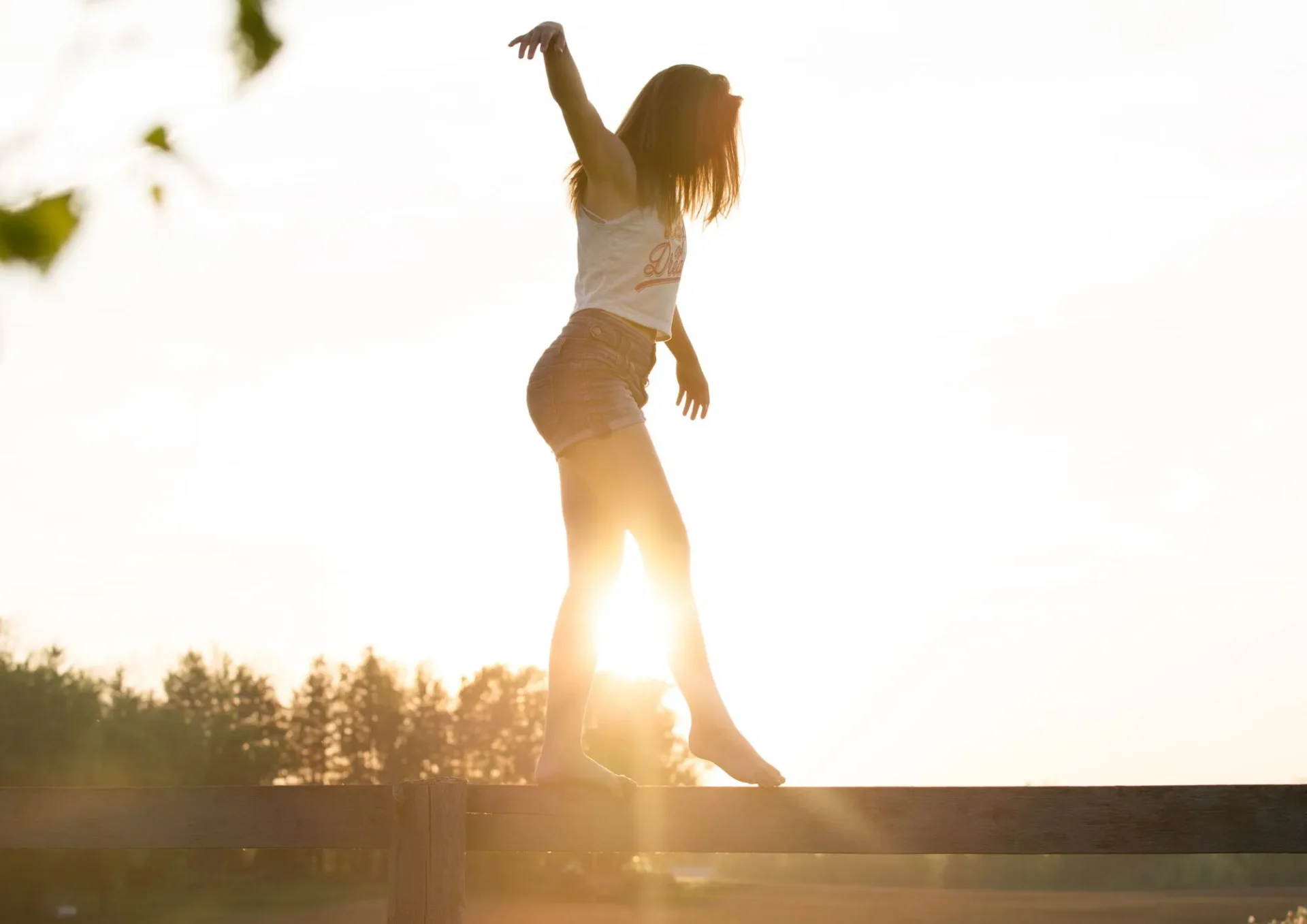 Une femme en équilibre dans sa vie devant le levé du soleil.