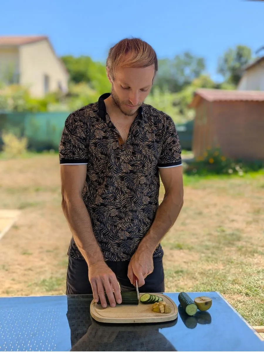 Yohann Vidal découpant un concombre en extérieur lors d’un coaching en nutrition holistique